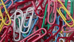 Multicolored rotating paper clips. Paper clips close up.