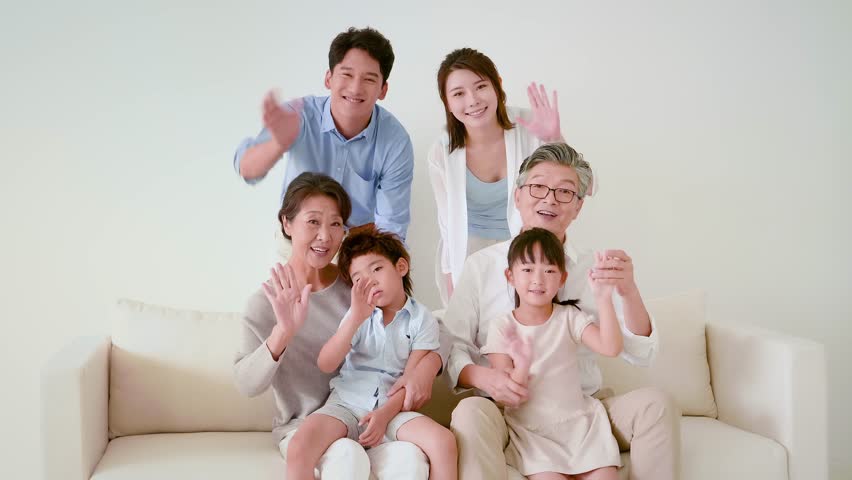Family with children and grandparents waving and smiling at camera in a living room, Beijing, China | Shutterstock HD Video #1106942323