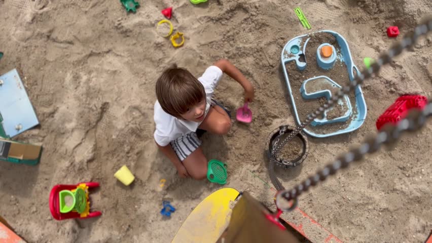 boy playing in the sandbox with a bucket and sand.  Royalty-Free Stock Footage #1106946107