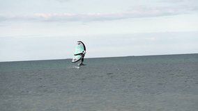 Modern water sport. Hydrofoil ride on the ocean using the wing and the power of the wind. the best place for kitesurfers, video of fit athlete practise hydro foil wing surfing 