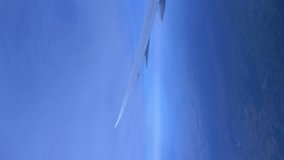 Vertical video of airplane flight above the clouds at night in 4K