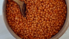 red lentils with wooden spoon rotate on a board.4k video footage
