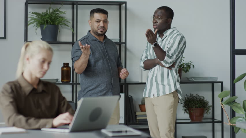 African American and Middle Eastern men standing behind their female co-worker slandering her on purpose Royalty-Free Stock Footage #1106955759