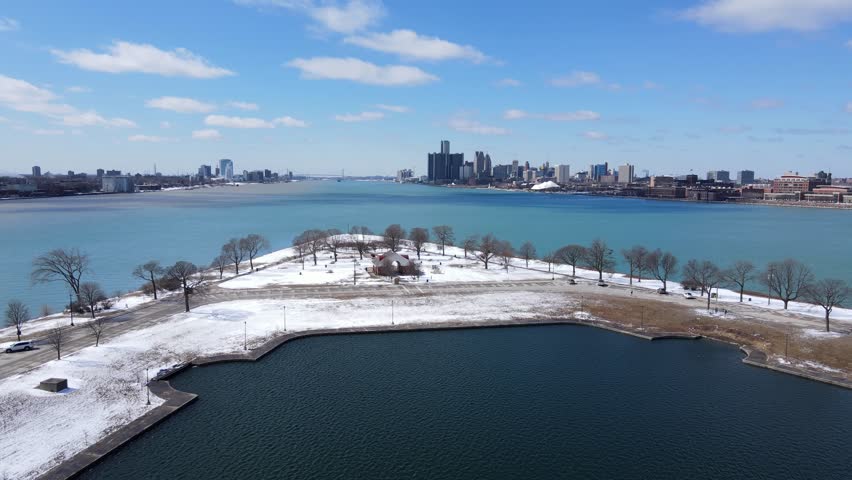Snow covered Belle isle and vast Detroit river with skyline, aerial view