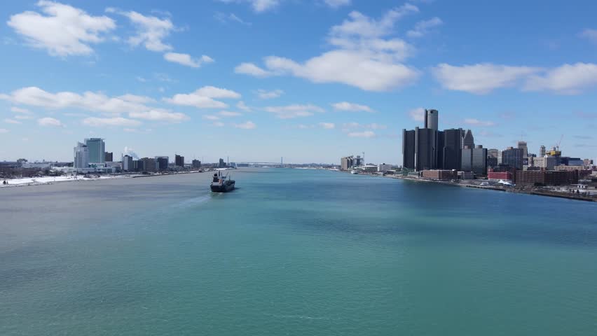 Freighter ship sailing in middle of Detroit river between Michigan and Windsor, aerial view