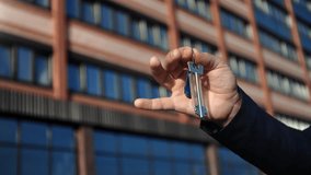 Business man hand holding keys real estate agency property buying residential apartment investment outdoor closeup. Successful male showing access new flat at modern city house mortgage banking loan - Powered by Shutterstock - Get 15% off with code: PIKWIZARD15