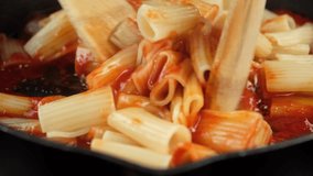 Cooking pasta with tomato sauce. Chef stir pasta with boiling tomato sauce, close up - Powered by Shutterstock - Get 15% off with code: PIKWIZARD15