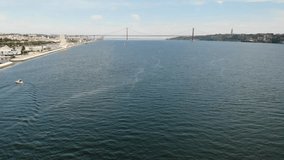 Tagus river Lisboa. 25 de Abril Bridge and Christ the King monument in Portugal. High quality 4k video