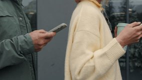 Close up of multiracial business people in casual clothes standing in line near office center and texting on personal smartphones. Busy partners checking news and working emails. - Powered by Shutterstock - Get 15% off with code: PIKWIZARD15