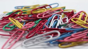 Multicolored rotating paper clips. Paper clips close up.