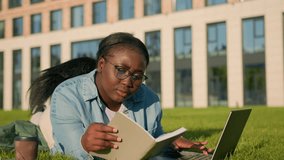 African American happy woman university college academy student teen girl high school lying on green grass in park studying with book copybook laptop computer drink coffee prepare for exam test study - Powered by Shutterstock - Get 15% off with code: PIKWIZARD15