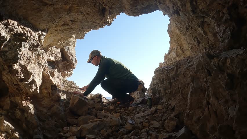 Man Rockhounding, Prospecting at Abandoned Mine in Desert Royalty-Free Stock Footage #1106997669