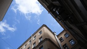 Low angle view of typical well shaped back yard in a sunny summer day in Saint-Petersburg city, Russia. Blue sky with whiteclouds. Real time handheld video. General architecture theme.