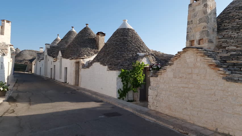 Alberobello Italy - traditional trulli houses with conical stone roofs. Famous landmark, travel destination and tourist attraction near Bari in Puglia, Europe. Street with ancient architecture. Royalty-Free Stock Footage #1107004841