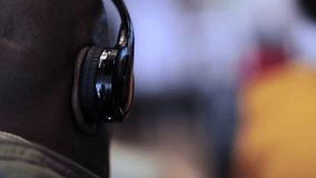 african-american man in headphones for translation at an international conference, listens to the translation in headphones. close-up of headphones on an African American, during a conference.