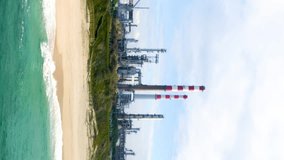 Aerial view power plant on the shore of the sea. Nature pollution by toxic chemicals. Wastewater treatment plant. Ecological disaster with plant at the shore of sea. Aerial vertical video. 