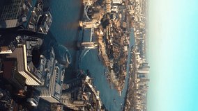 Establishing Aerial View Shot of London City Skyline. Tower Bridge in foreground, Canary Wharf in background United Kingdom. 
Aerial vertical, vertical video background.