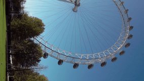London Eye ferris wheel over Thames River in London Great Britain. UK, England. Aerial vertical, vertical video background.