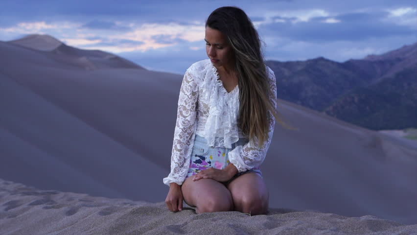 Female women actress Model sitting atop Colorado The Great Sand Dunes National Park reflecting looking down drawing finger scenic mountain landscape dusk purple adventure Rocky Mountain still movement