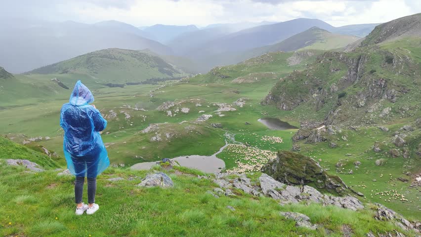 A beautiful Ukrainian young woman traveler walks along the most beautiful high mountain road in Romania Transalpina highway at day. Transalpina, Carpathian mountains in Romania