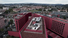 drone shot over Saint Etienne business district and Chateaucreux train station with red design building in the foreground during the day - Powered by Shutterstock - Get 15% off with code: PIKWIZARD15