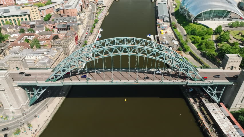 4K Aerial of Newcastle Upon Tyne. Sunny Day. Slow Pull back over the Tyne Bridge with cars driving over it to reveal the millenium bridge off in the distance. Royalty-Free Stock Footage #1107024087