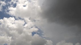 Cumulonimbus clouds move alongside dark clouds