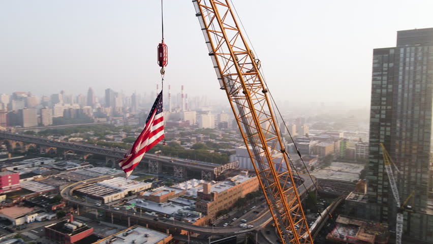 Drone Shot of The American Flag flying above New York City construction site