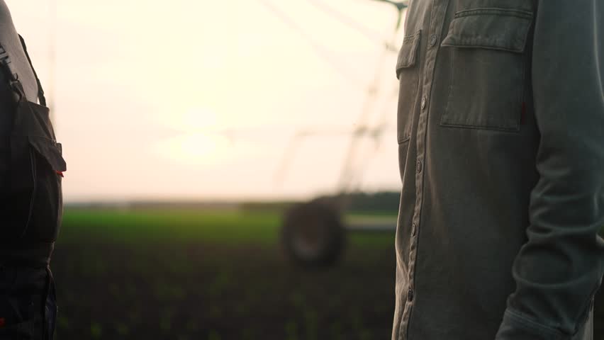 farmers handshake business contract. two farmers at sunset with corn irrigation plant in the background shaking hands. agriculture irrigation business concept. farmers lifestyle handshake Royalty-Free Stock Footage #1107032779