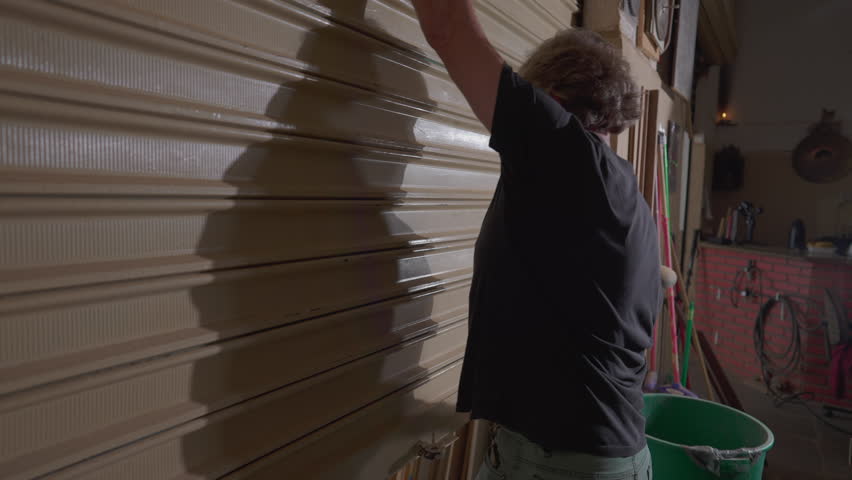 Local Business owner opening up shop, sliding garage door of carpentry store