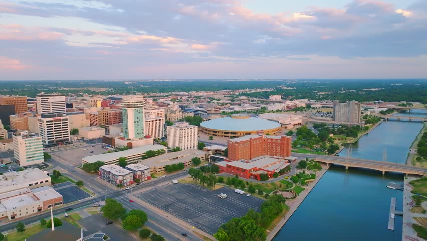 The drone footage over the Arkansas river running through the Wichita city downtown under the blue sky