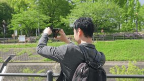 Asian man shooting landscape with smartphone. tourist.
