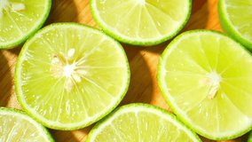 In a captivating macro video, half green lemons reveal nature's artistry. Vivid hues blend seamlessly with delicate textures, a citrus symphony. Fruit concept
