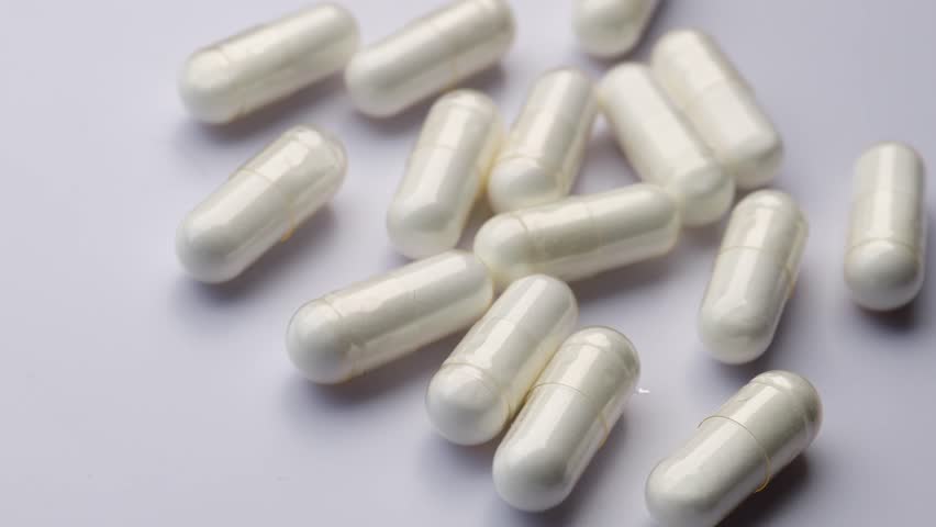 white pharmaceutical capsules, rotation in circle. Collagen capsule on a white background Turning. selective focus. Virus medication concept. vitamin, Medicine chest