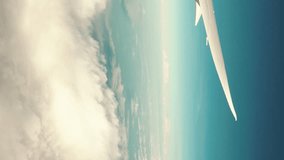Airplane flight. Flying above the clouds. View from the window of the plane. Traveling by air. Vertical video background.