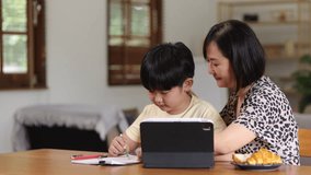 Asian young kid learning online class at home with mother and father, Digital technology, Learning, Guidance, Education, Asian family and children doing homework concept.