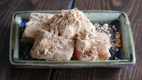 A close-up video of warabimochi covered with brown sugar syrup.