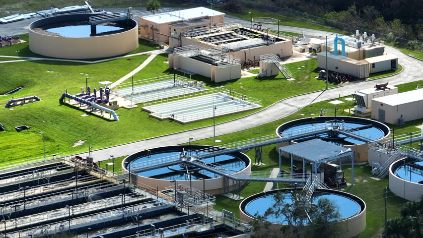 Aerial view of modern water cleaning facility at urban wastewater treatment plant. Purification process of removing undesirable chemicals, suspended solids and gases from contaminated liquid Royalty-Free Stock Footage #1107063599