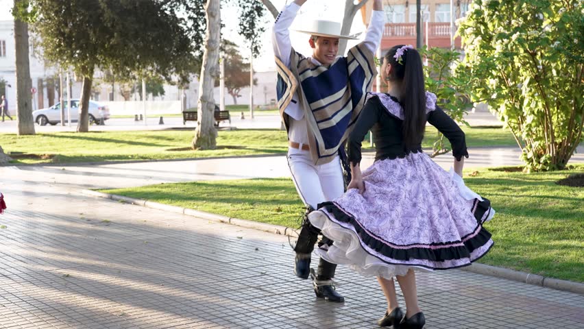 Young latin american couple dancing cueca national dance with huaso traditional clothing	 | Shutterstock HD Video #1107064305