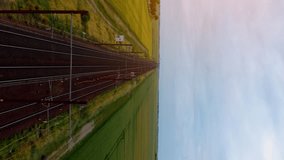 Aerial footage of a freight train. Freight Train Passing Through Countryside. Aerial view of train.  Aerial vertical, vertical video background.