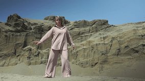 woman dancing in the desert. one woman in the desert. dancing caucasian woman in casual clothes. High quality Full HD video recording