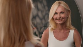 Beautiful mature Caucasian old woman smile look blurry mirror reflection in bathroom healthy skin natural makeup skincare routine anti aging lifting moisturized cosmetic face wrinkles beauty self love - Powered by Shutterstock - Get 15% off with code: PIKWIZARD15