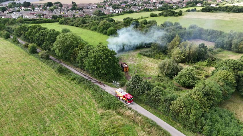 Firemen putting out rubbish fire in Essex UK aerial fire engine parked in country lane Royalty-Free Stock Footage #1107071653