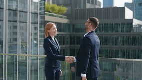 Side view two successful business partners male female handshaking meet and shake hands coming to each other on office building rooftop terrace overlooking high-rise skyscrapers modern city downtown - Powered by Shutterstock - Get 15% off with code: PIKWIZARD15