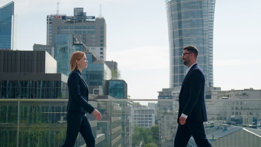 Side view two successful business partners male female handshaking meet and shake hands coming to each other on office building rooftop terrace overlooking high-rise skyscrapers modern city downtown Royalty-Free Stock Footage #1107072541