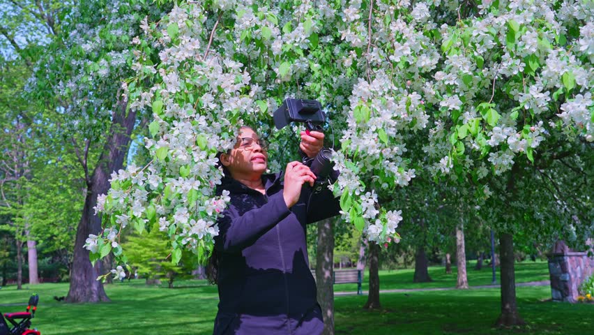 Filmmaker with semi professional camera set up rig with camera cage and big preview cinema monitor. African American female cinematographer portrait. Cinematic slow motion. Content creator with camera