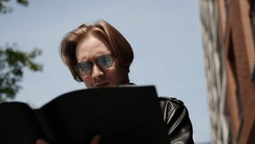 The student looks at the folder with documents. A man reads graphs and tables. Slow motion, bottom angle. Stylish blonde. - Powered by Shutterstock - Get 15% off with code: PIKWIZARD15