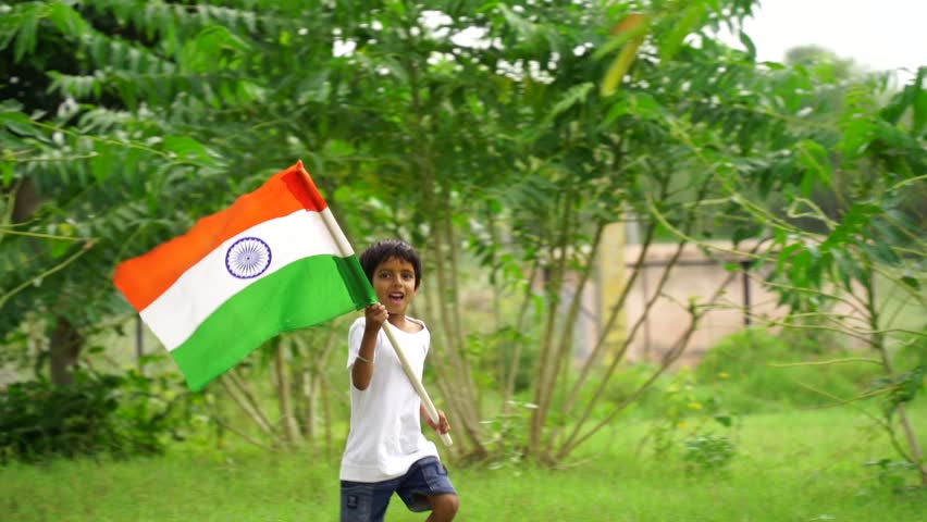 Cute little Indian kids holding, waving or running with Tricolour with greenery in the background, celebrating Independence or Republic day