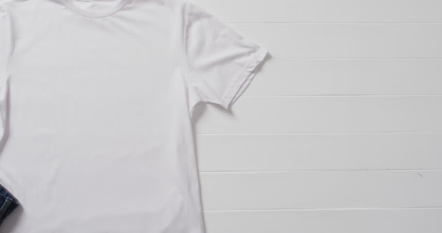 Video of white t shirt, denim trousers and copy space on white background. Clothing, fabric, texture and materials concept. Royalty-Free Stock Footage #1107098307