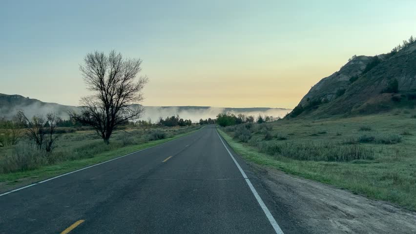 Driving through the smokey badlands hills and mountains in Theodore Roosevelt National Park in North Dakota.